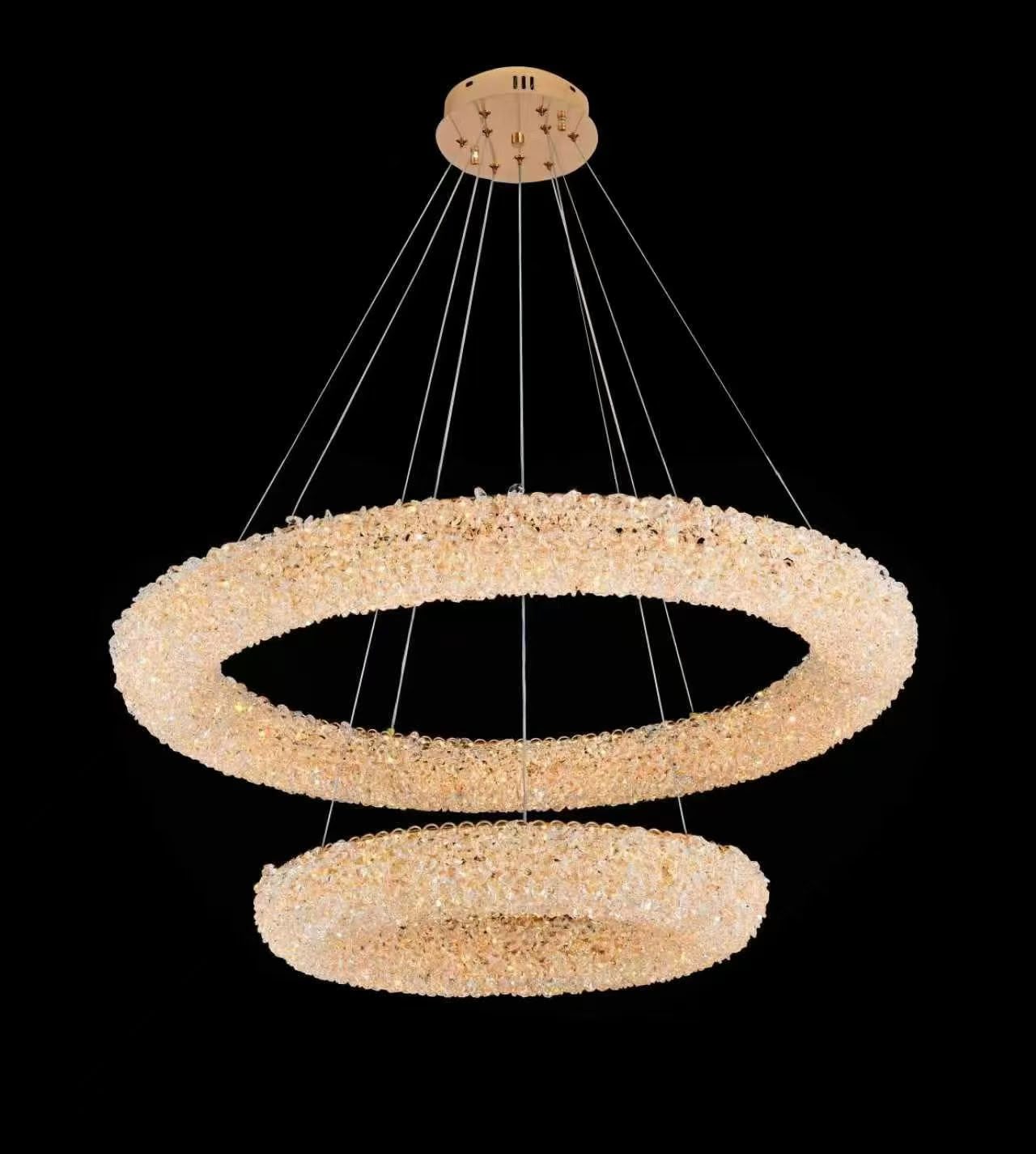Two-tier crystal ring chandelier lit against a dark ground